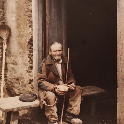 Arquivo do Reino de Galicia. Colección fotográfica. Ancián a comer nun banco na porta dunha casa. Ca. 1910-20. Sign. 6163