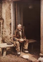 Arquivo do Reino de Galicia. Colección fotográfica. Ancián a comer nun banco na porta dunha casa. Ca. 1910-20. Sign. 6163